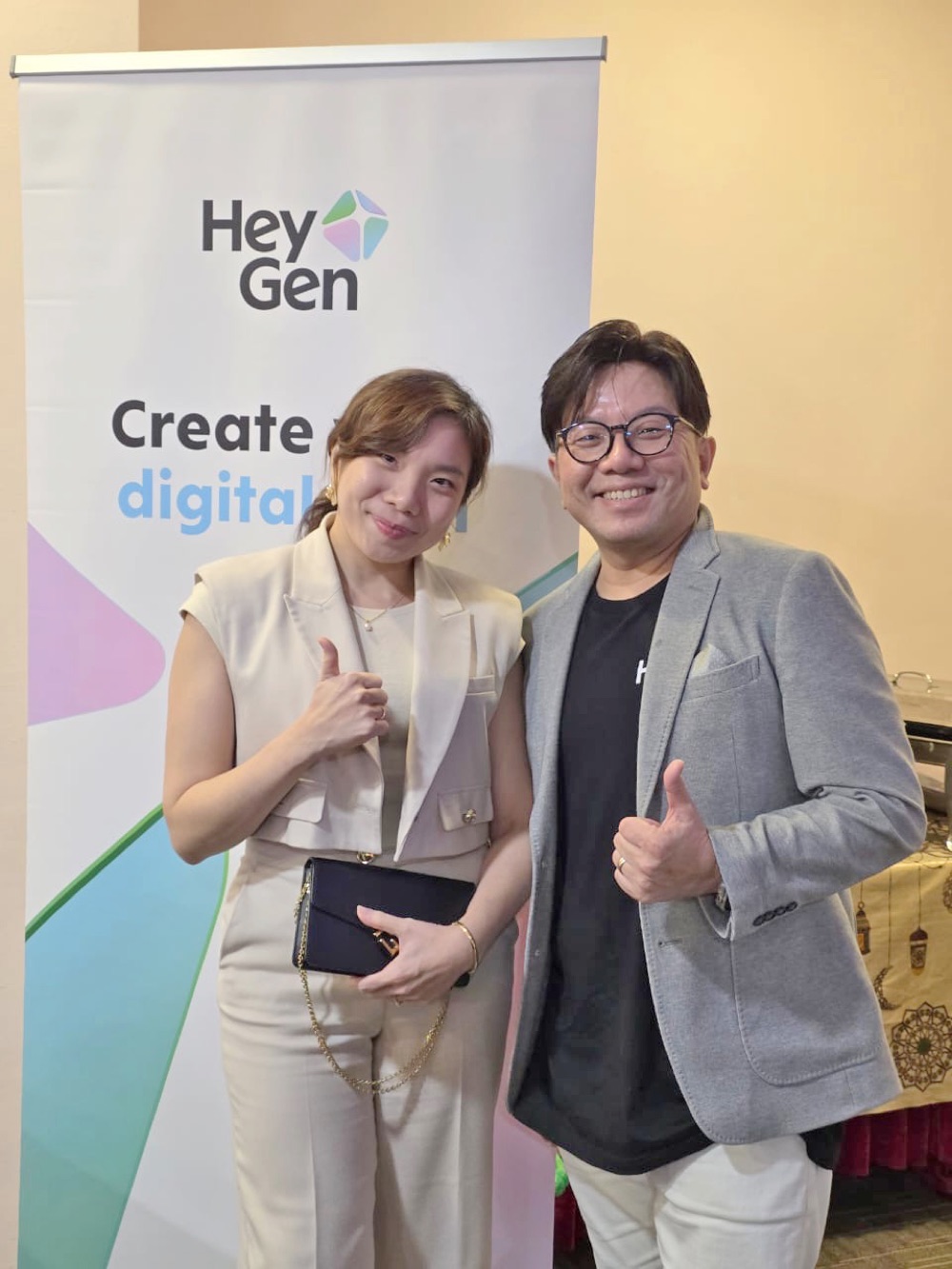 Han Yong with an event guest in front of the HeyGen display